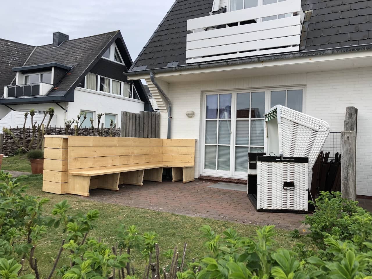 Bank aus hellem Holz im Garten eines Haus auf Sylt